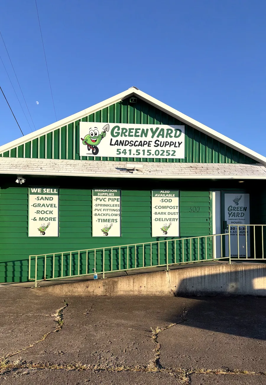 The Green Yard Landscape Supply building on Queen Ave, green with white trim, under a blue sky