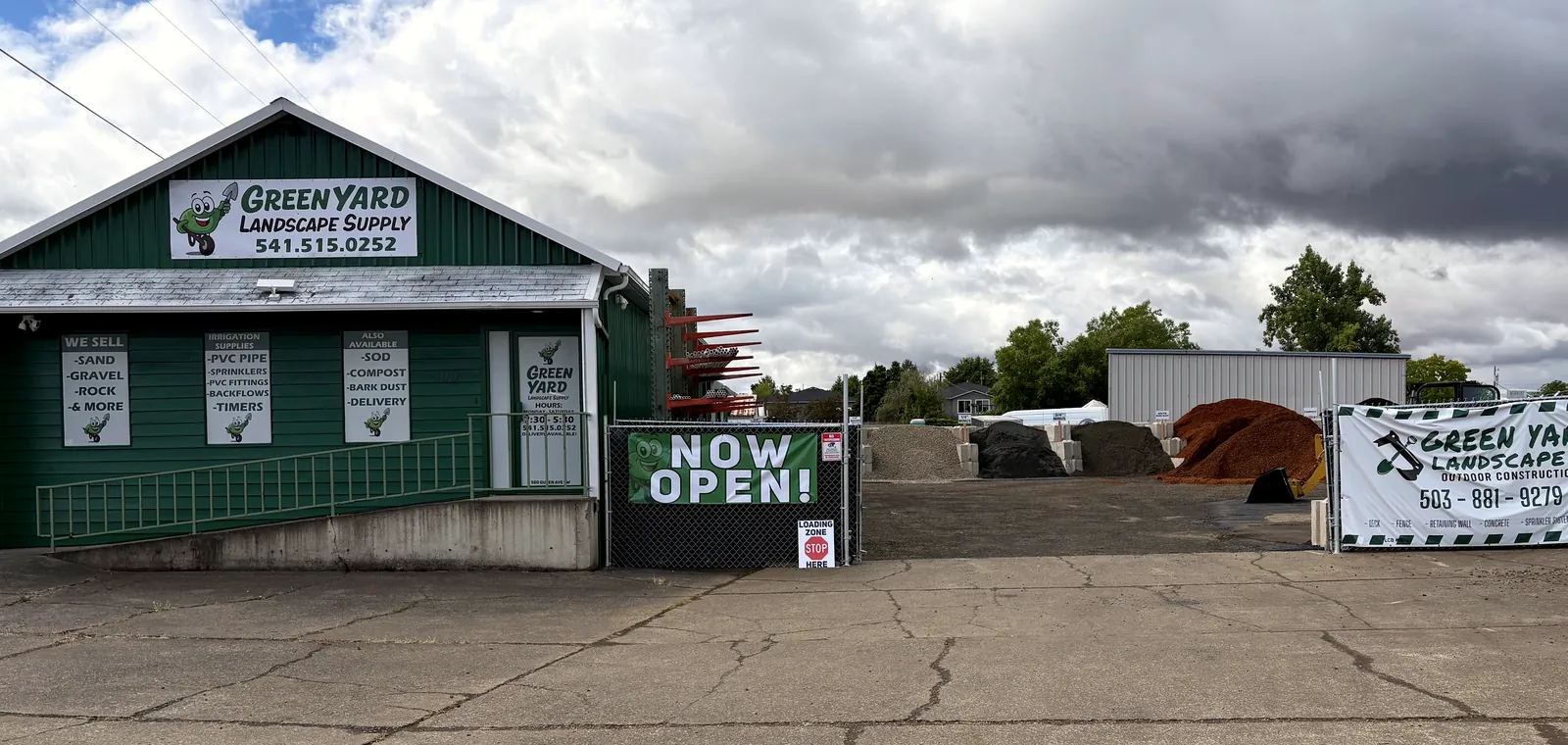 The yard in its opening weeks: the green building, the NOW OPEN banner and the bays behind the fence